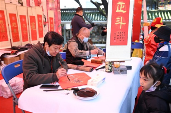 1月18日，书法家在水上花市启动仪式上为市民写春联。新华社记者 邓华 摄