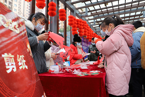 居民在老师的指导下参与剪纸体验。通讯员 杨彦 摄