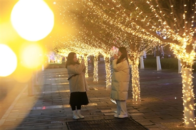 双桂城区桂西路，市民在绚丽多彩的迎春灯饰下拍照。记者 向成国 摄