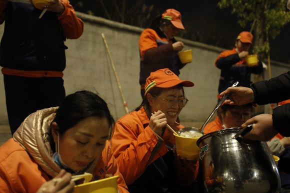 凌晨1时30分，热心的南川市民为在冷风中清扫保洁的环卫工人们送来了在自家煮好的饺子。通讯员 罗建 摄