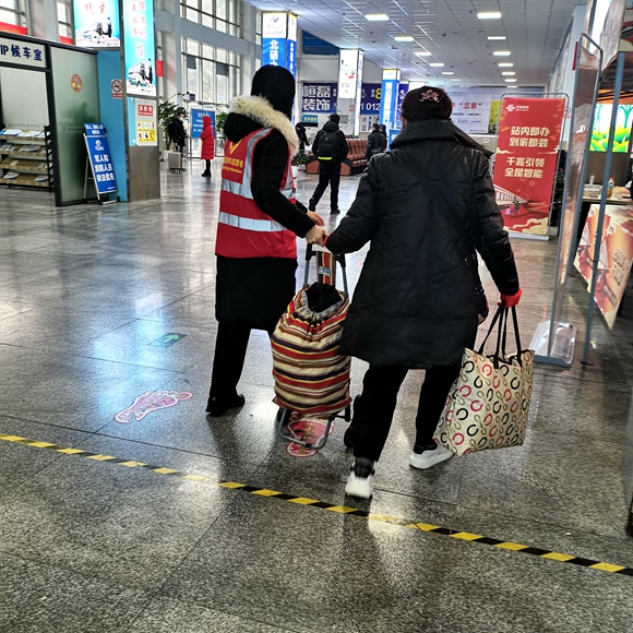 志愿者正在帮旅客搬运行李。北碚区委宣传部供图 华龙网发