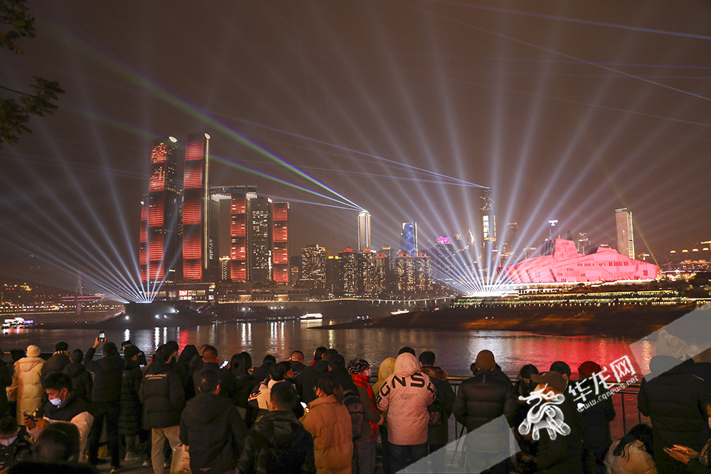 市民在南滨路观看灯光表演。华龙网-新重庆客户端 首席记者  李文科 摄