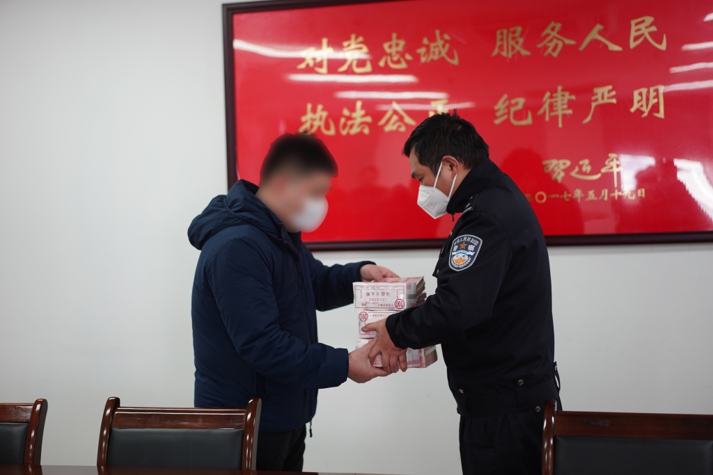 0民警向受害企业代表返还涉案资金。重庆市九龙坡区警方供图