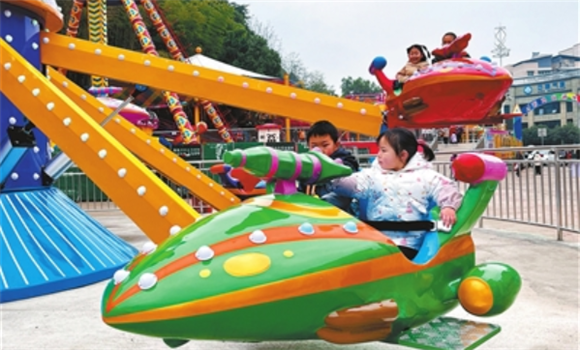 1月2日，石马山游乐园，小朋友在体验自控飞机游乐项目。记者 郑君兴 摄