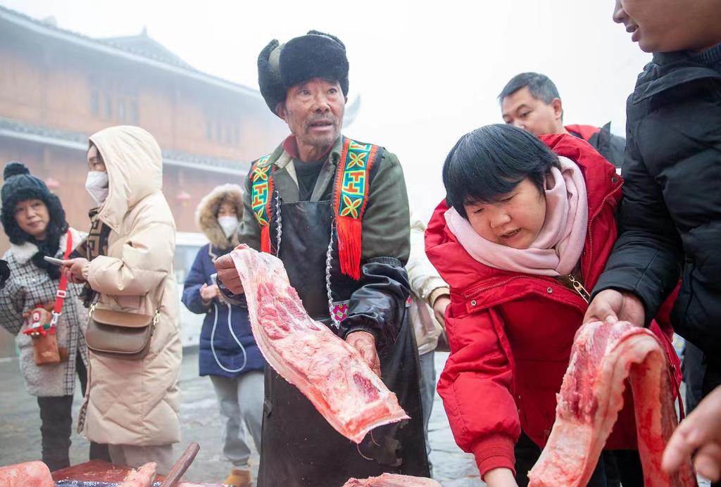 刨猪宴现场，游客正在挑选土猪肉。南川区文化旅游委供图
