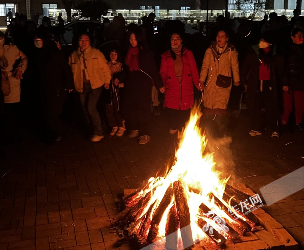 村民们围着篝火伴着歌声跳着拉手舞。华龙网-新重庆客户端记者 曹建 摄