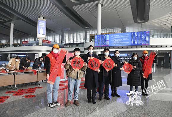 13、重庆西站工作人员为旅客送上春联，暖意浓浓。华龙网-新重庆客户端 记者 李文科 摄
