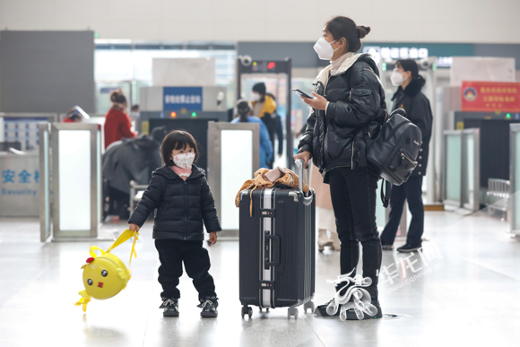 11、重庆北站，毛女士带着三岁的女儿贝贝，准备乘坐高铁回甘肃老家。华龙网-新重庆客户端记者 石涛 摄