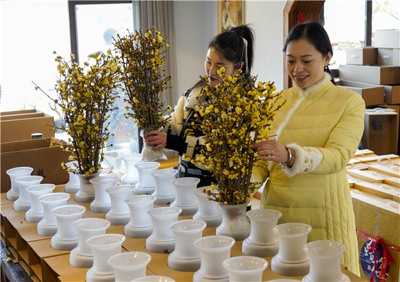 在重庆市北碚区静观镇一家创意工坊，插花师在整理顾客订购的腊梅花。新华社记者 刘潺 摄