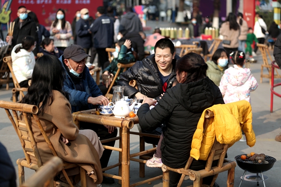 游客围坐在一起，一边品着美食，一边享受难得的冬日暖阳。美心红酒小镇供图 华龙网发