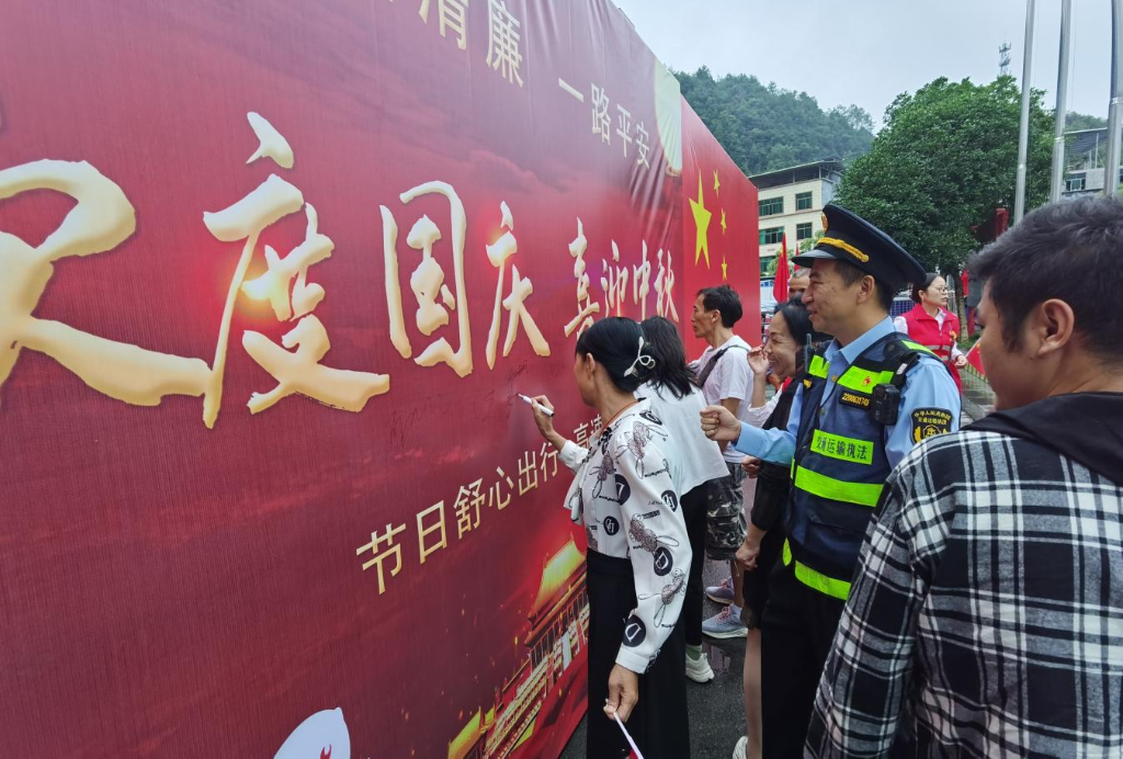 9月29日，在酉阳服务区，游客在签名墙签名。重庆市交通运输综合行政执法总队供图