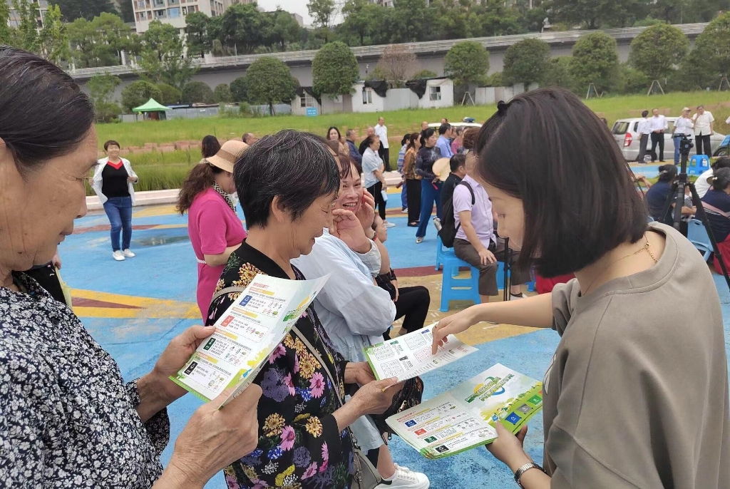 志愿者向附近居民派发宣传手册。通讯员 王希 摄