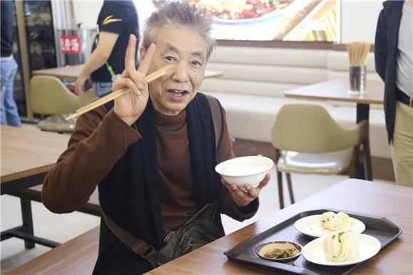 67岁刘大爷吃着早餐。黎名 摄