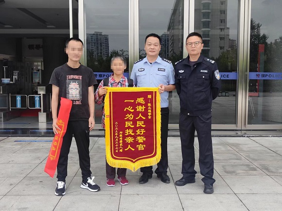 邱某将锦旗送往垫江县公安民警手中。白超摄