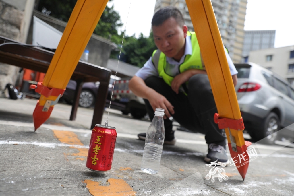 工作人员正观测振动的垂直吊起的易拉罐和置于地面的盛水容器的水面。华龙网首席记者 李文科 摄
