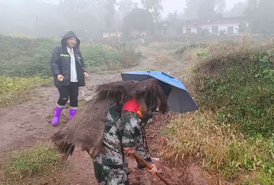 05  10月19日，水流村群测群防员王安然（左）检查排水沟是否通畅。