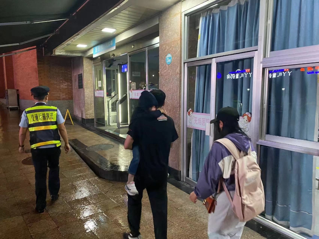 执法队员将小孩一家人送到医院。重庆交通执法部门供图