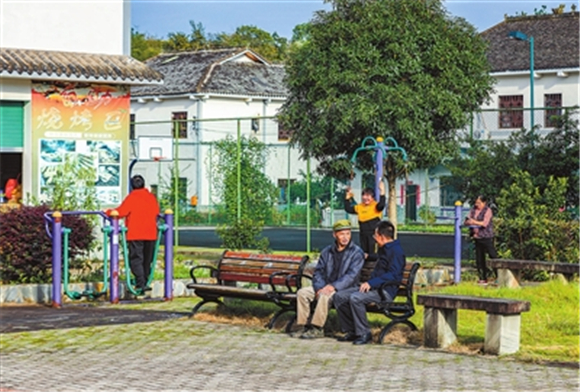 近日，金带街道滑石村，村民在阳光下聊天、健身。记者 熊伟 摄