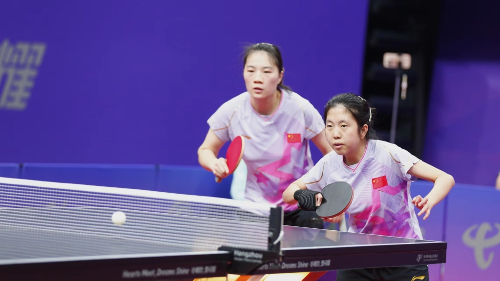图说：重庆15岁小将金芋成（右）与队友黄文娟搭档，获得杭州亚残运会乒乓球女子双打Class WD14冠军