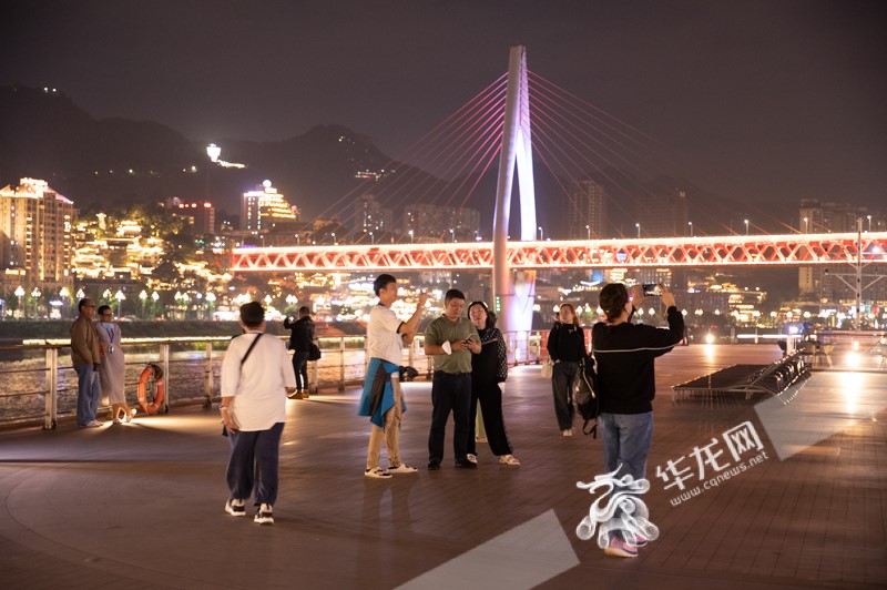  Before the cruise ship departs, Thai tourists enjoying the night view of Chongqing on the deck.