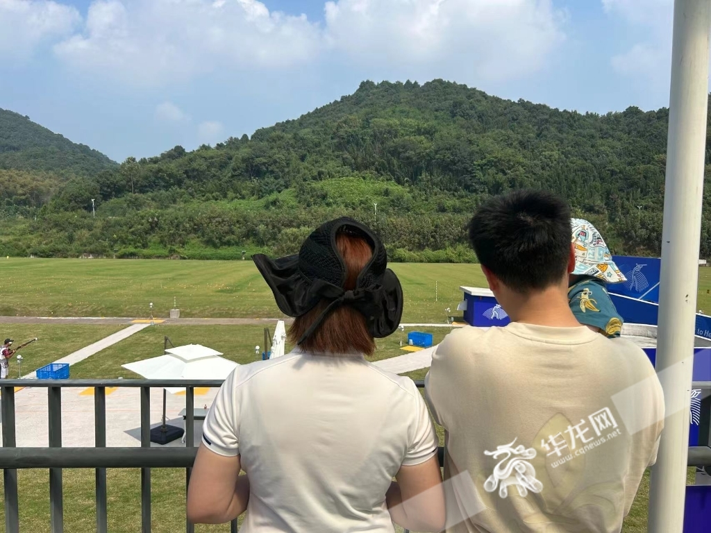 The wife of Liu Jiangchi (first from right), holding her son at the side of the field, watches the games.