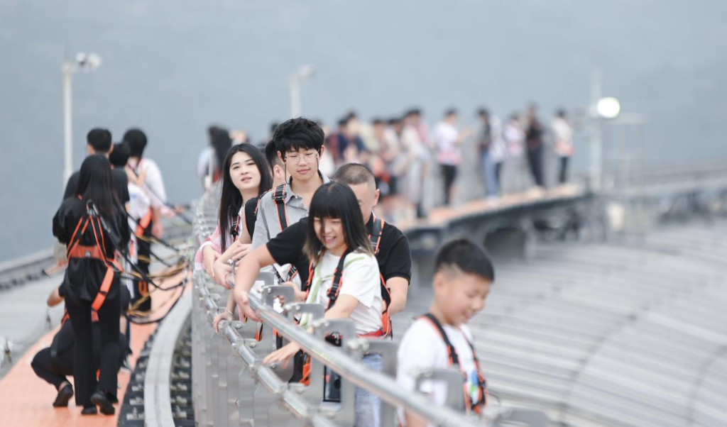中秋国庆期间，游客正在体验重庆来福士探索舱·云端乐园“云中漫步”高空项目。受访企业供图
