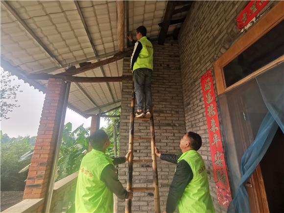 商会工作人员帮助改造房屋。通讯员 赵武强 摄