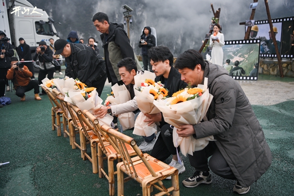 主创为牺牲的村民献上鲜花。重庆电影集团供图
