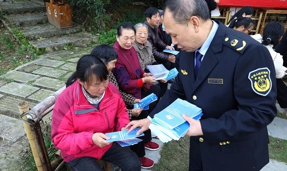 工作人员向村民发放宣传手册。华龙网 陈稼轩 摄