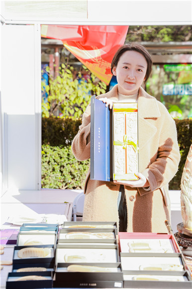 吴娟向市民展示龙凤工艺品。重庆市乡村振兴局供图