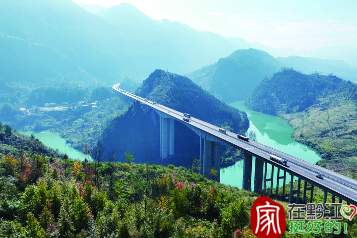 汽车行驶在彩叶林掩映的渝湘高速黔江区阿蓬江特大桥上。
