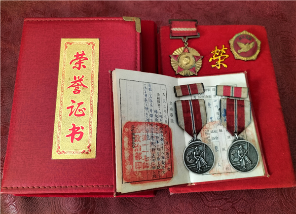 秦叙银老人获得的军功章和荣誉证书。