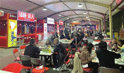 中国西部预制菜之都梁娃·食尚夜市，市民在品尝美食。记者 高柔 摄