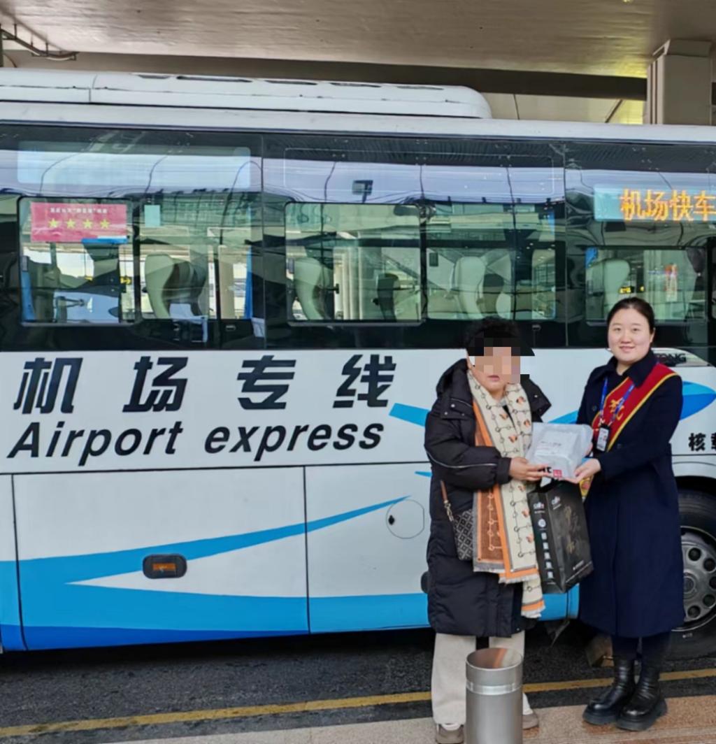 机场快车K01线地勤李梦媛把失物交还失主程女士。重庆两江公交供图