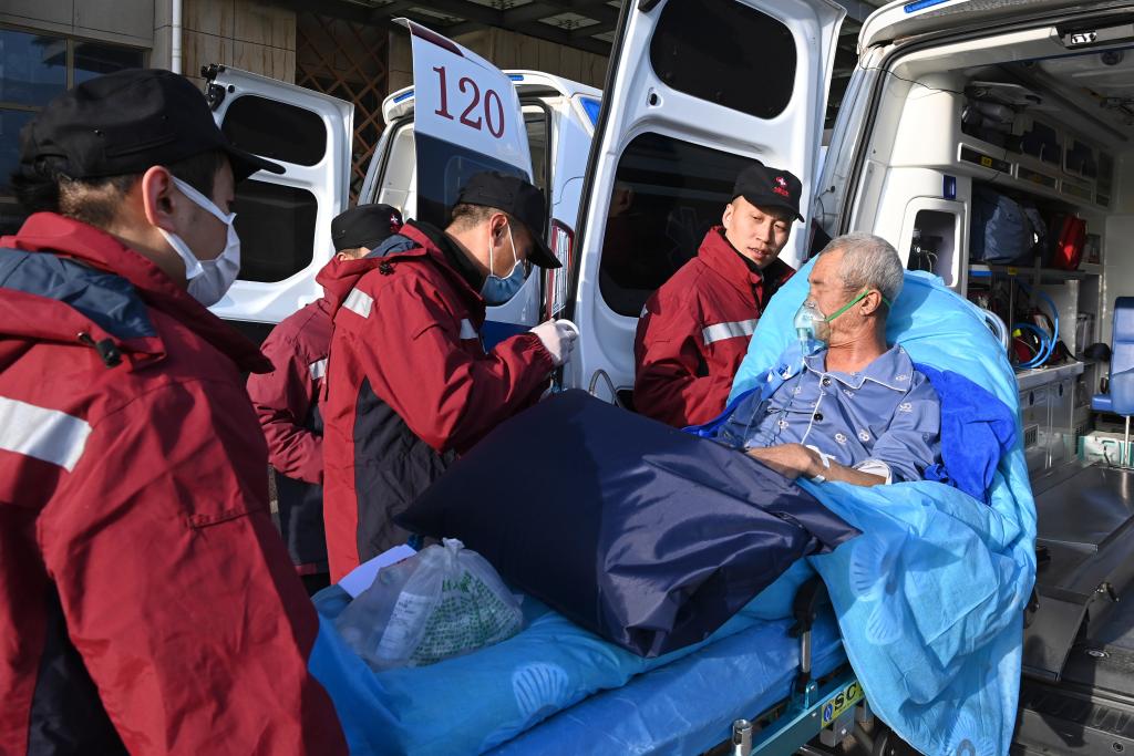  12月21日，在临夏州人民医院，急救人员将重症伤员抬上转运救护车。