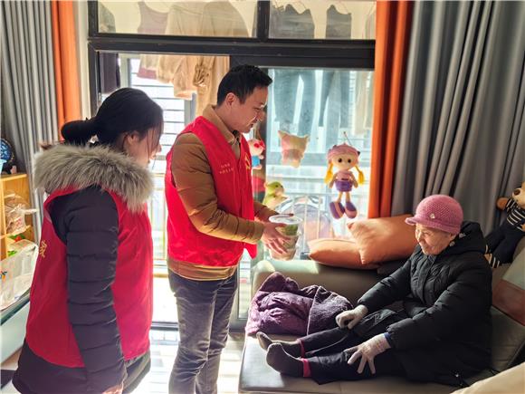 党员志愿者为独居老人送饺子。学成社区供图