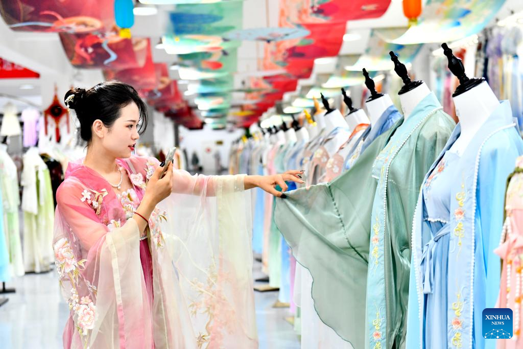 A woman sells Hanfu via livestreaming in Ancailou Township of Caoxian County, east China's Shandong Province, July 6, 2023. (Xinhua/Guo Xulei)