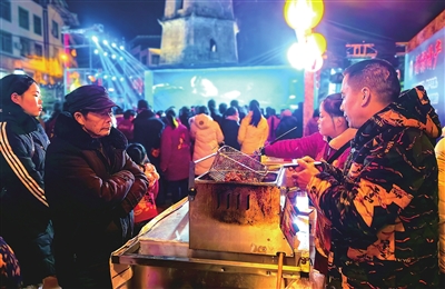福禄镇天香广场，游客在福禄冬至夜市购买美食。记者 周茜 摄