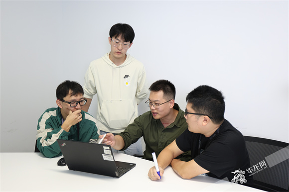 王郑旭带领同事讨论技术难题。华龙网记者 王庆炼 摄