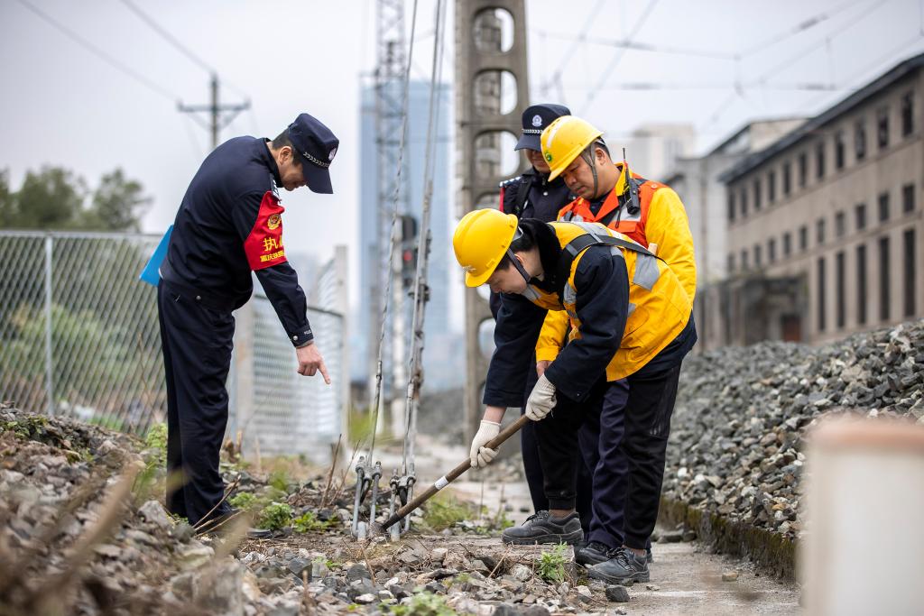 民警协同铁路职工对线路隐患进行排查。胡勇 摄