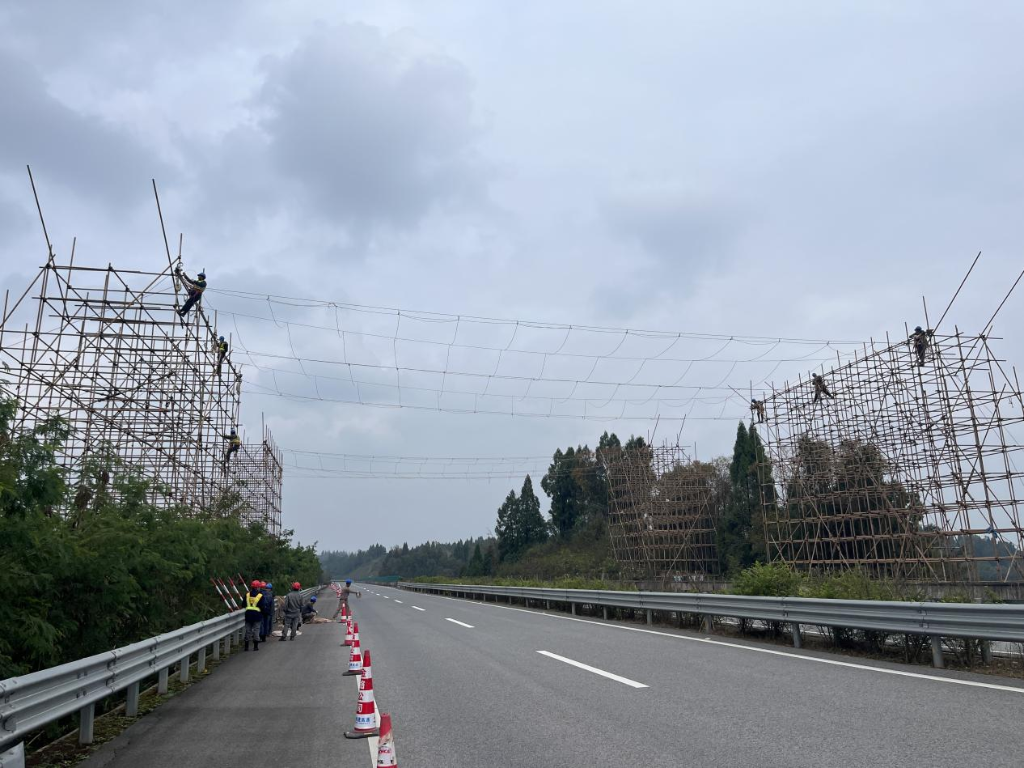 川渝特高压线路工程（重庆段）跨越潼荣高速现场进行跨越架封网工作，保障下方高速通行安全。通讯员 王清远 摄