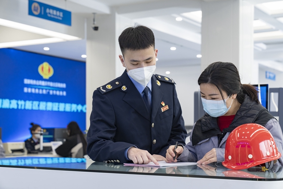 在川渝高竹新区税费征管服务中心,税务人员辅导纳税人办理跨区域涉税业务。 通讯员 郭睿 摄