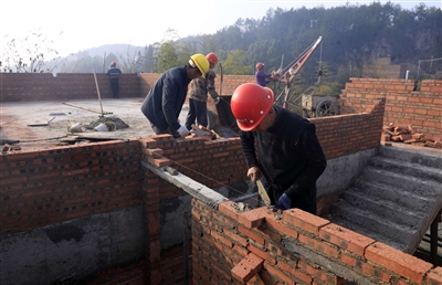 近日，蟠龙镇蟠龙村油茶加工厂建设现场，工人在砌墙。 记者 向成国 摄