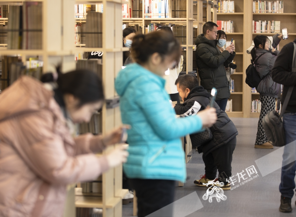 Many people in the reading area on the second floor take photos and visit.
