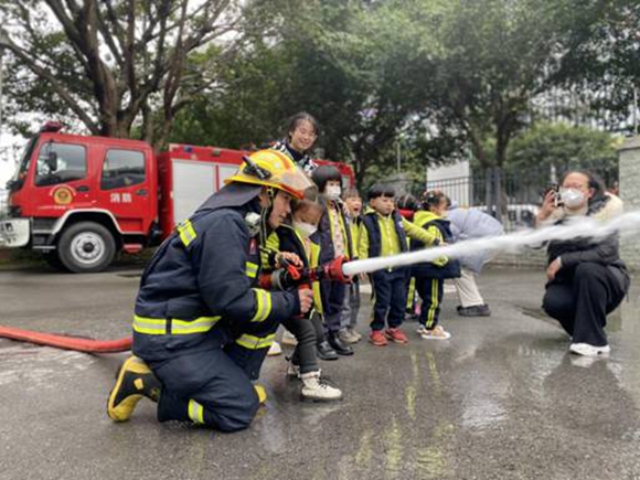 小朋友体验消防水枪。通讯员 蒲丽娜 供图