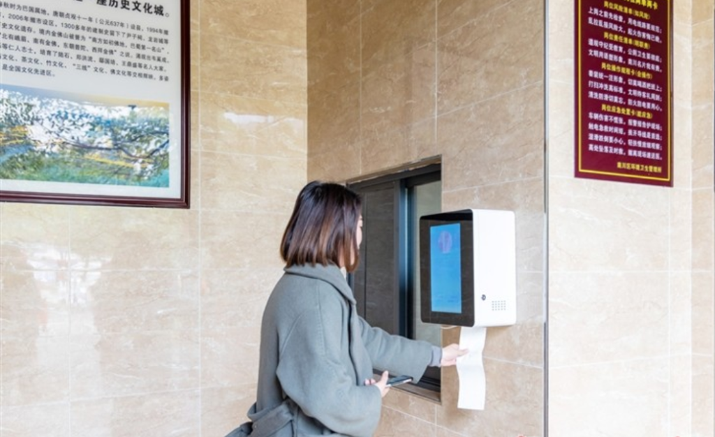 市民在智能出纸设备前“面对面”取厕纸。罗建 摄