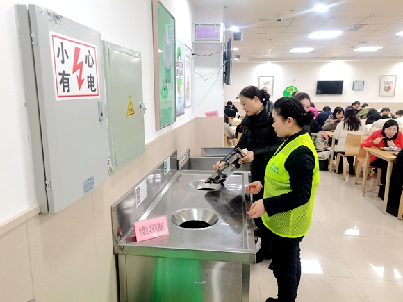 食堂工作人员协助就餐人员分类处理食物残渣。仙桃街道办事处供图 华龙网发