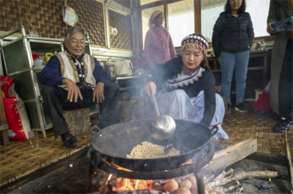 2月22日，云南省福贡县施底村秘境湾景点的村民向游客展示傈僳族传统方式制作爆米花。新华社记者 陈欣波 摄