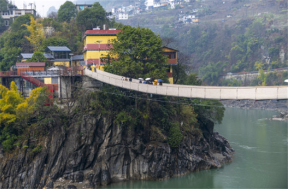2月22日，游客通过架设在怒江上的吊桥进入云南省福贡县施底村秘境湾。新华社记者 陈欣波 摄