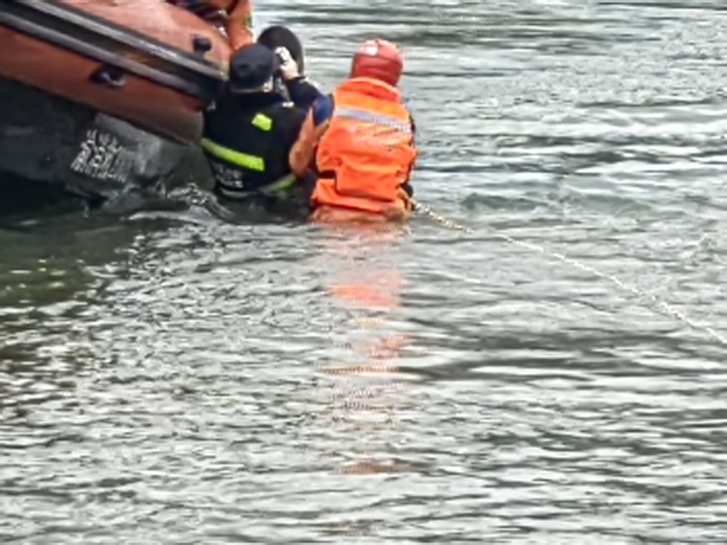 3民警与消防员一起将女子救上船。重庆沙坪坝警方供图